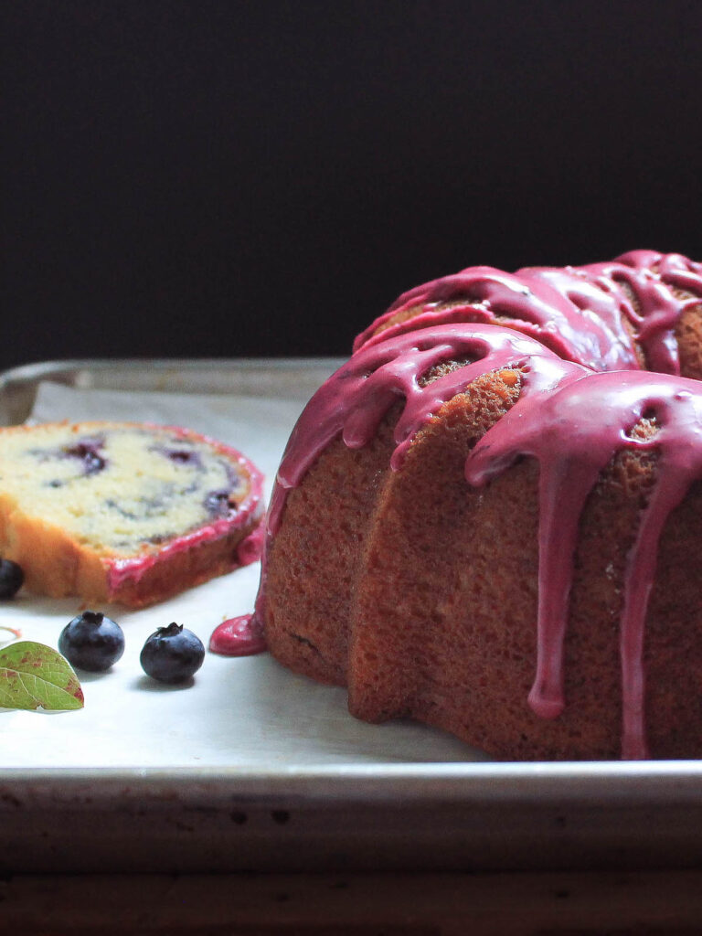 Blueberry glaze dripping off a bundt cake