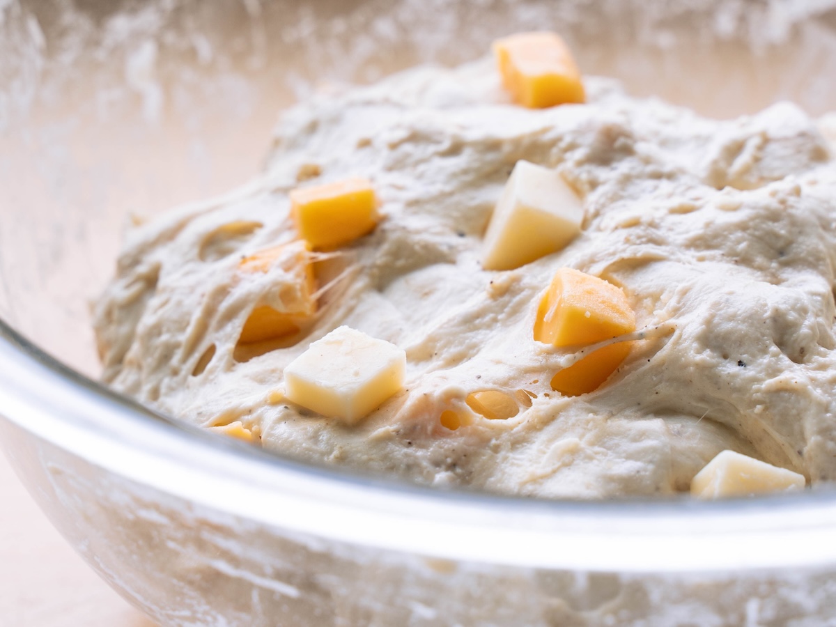 Close up look at gluten structure in sourdough bread dough with chunks of cheese in it