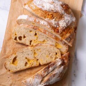 A loaf of homemade cheesy sourdough bread sliced