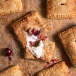 Freshly baked cherry hand pies, with one pie broken open to show filling