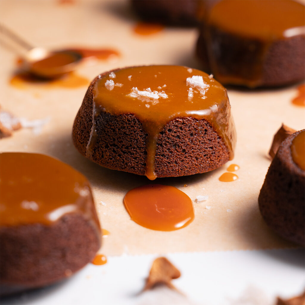 Miniature chocolate cakes drizzled with candy cap caramel sauce