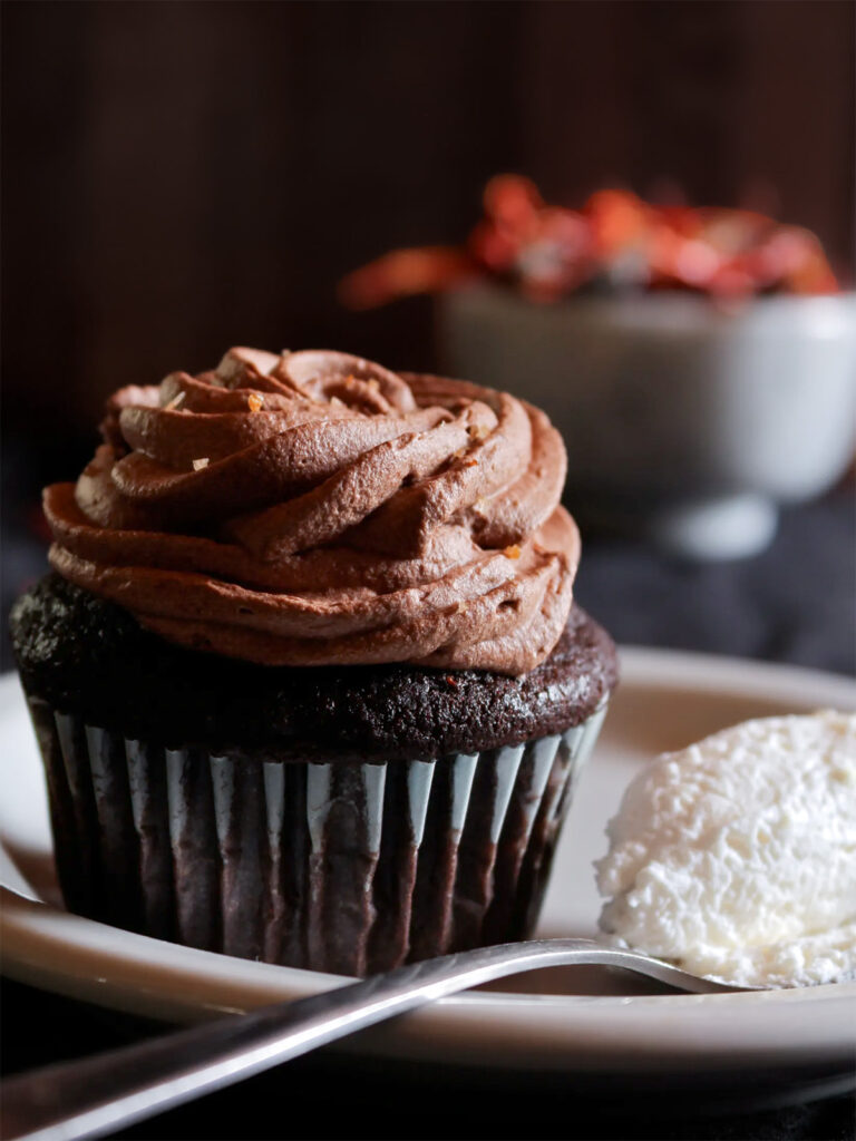 A chocolate chili cupcake with a spoonful of fresh ginger whipped cream