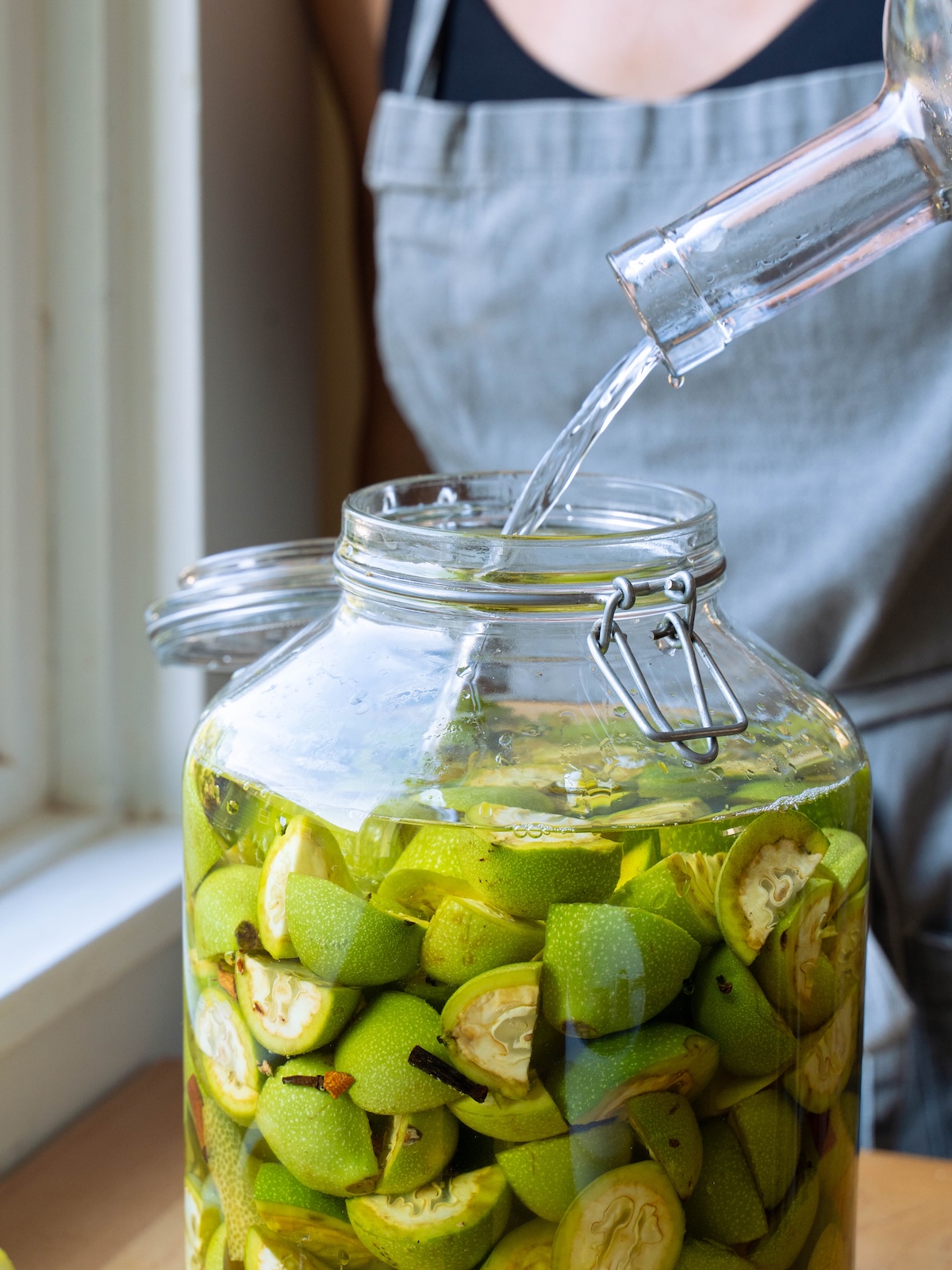 Submerging green walnuts and spices in vodka