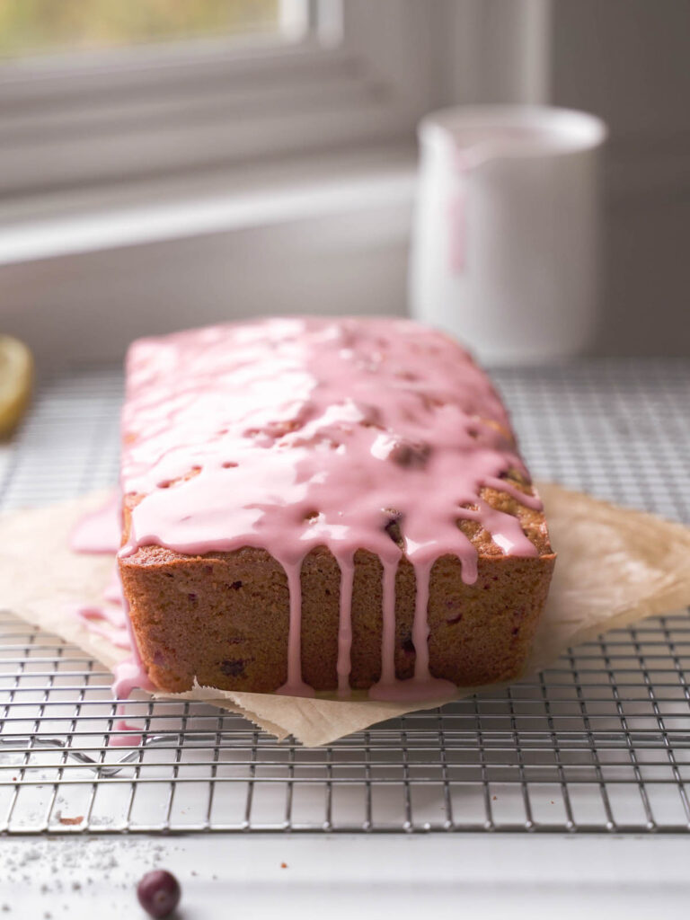 Glaze dripping off a cranberry almond cake