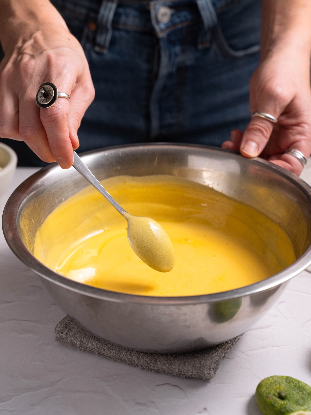 Fresh homemade mango curd coating the back of a spoon