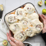 A pan of freshly frosted fig & brie cinnamon rolls