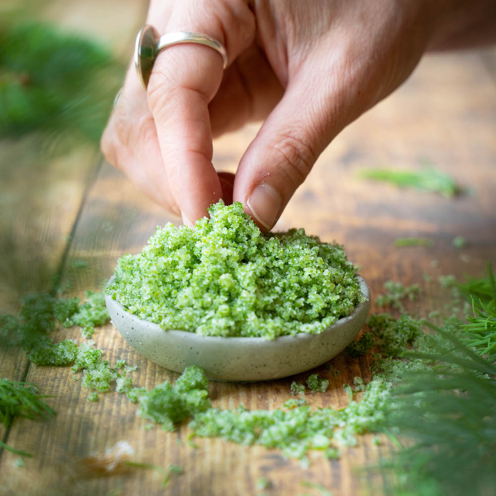 Fingers pinching fir tip sugar out of a small bowl