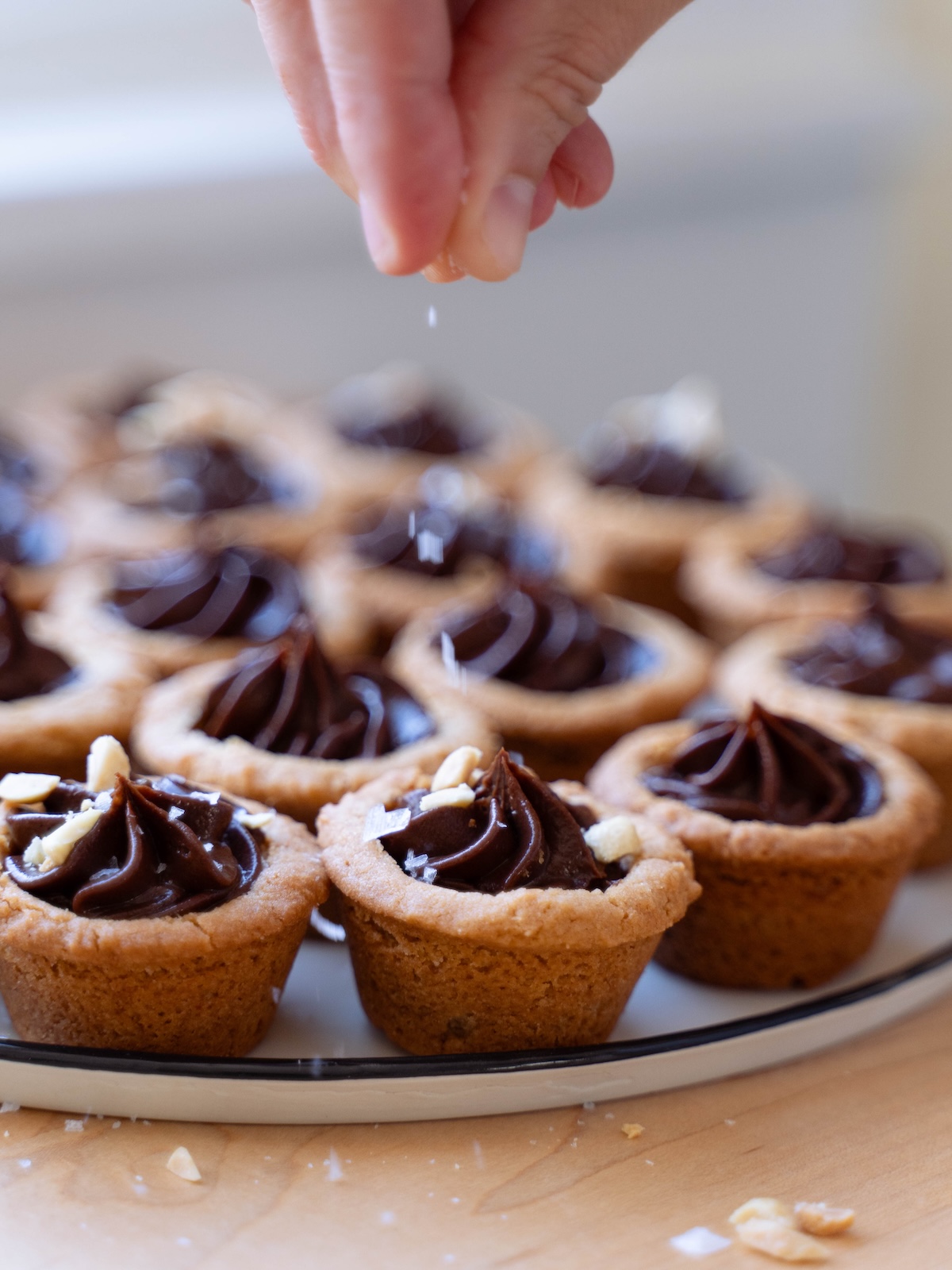 Sprinkling sea salt onto cookie cups