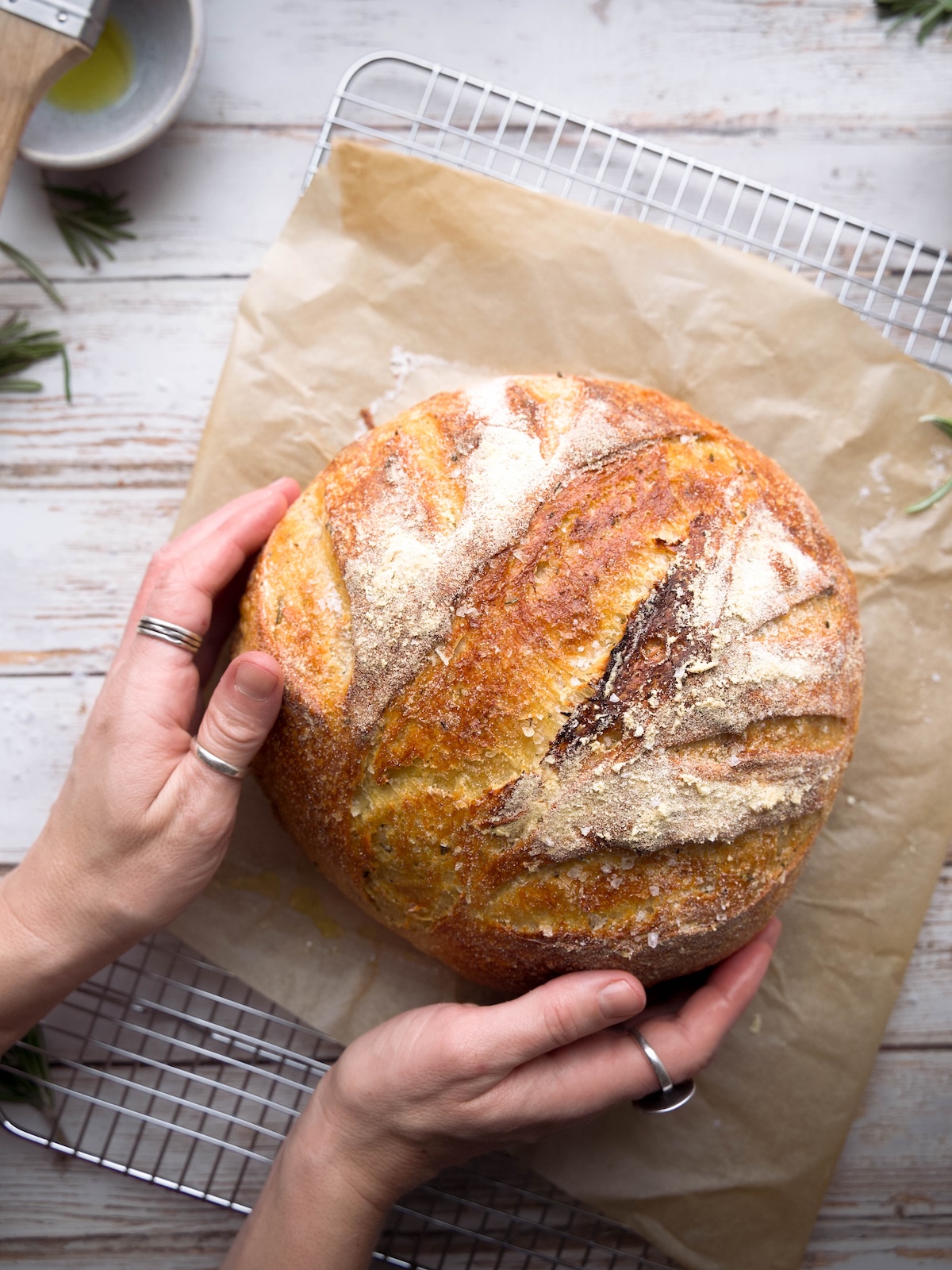 Hands holding a homemade sourdough boule