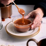 Salted caramel sauce dripping off a spoon