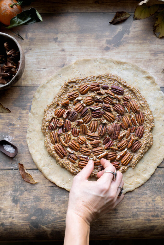 Placing pecans in a spiral pattern for a galette