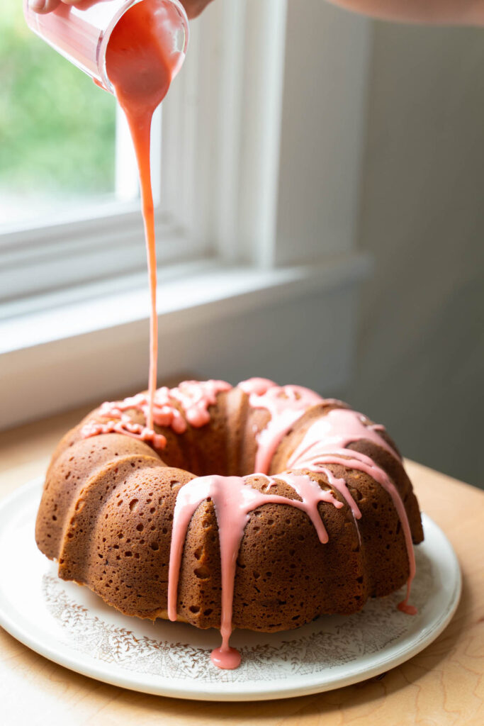 Glazing a bundt cake with strawberry glaze