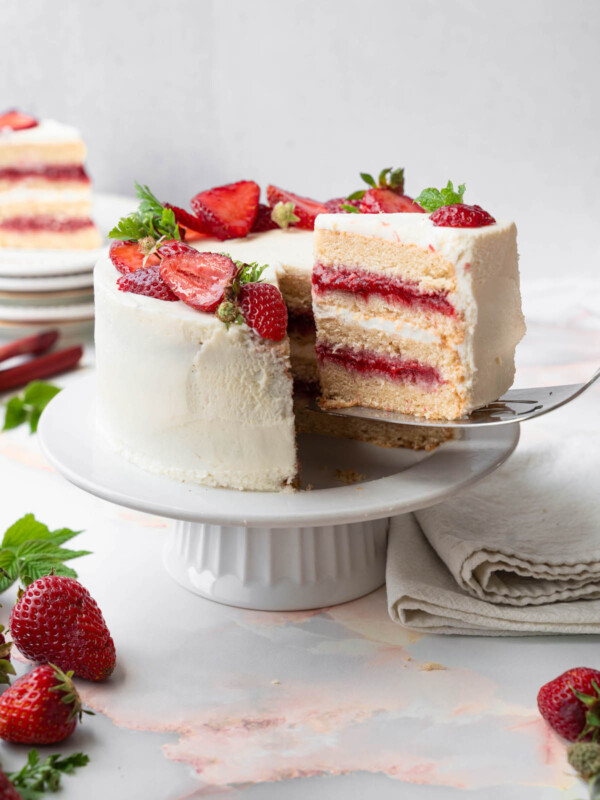 A slice being taken out of a strawberry rhubarb cake