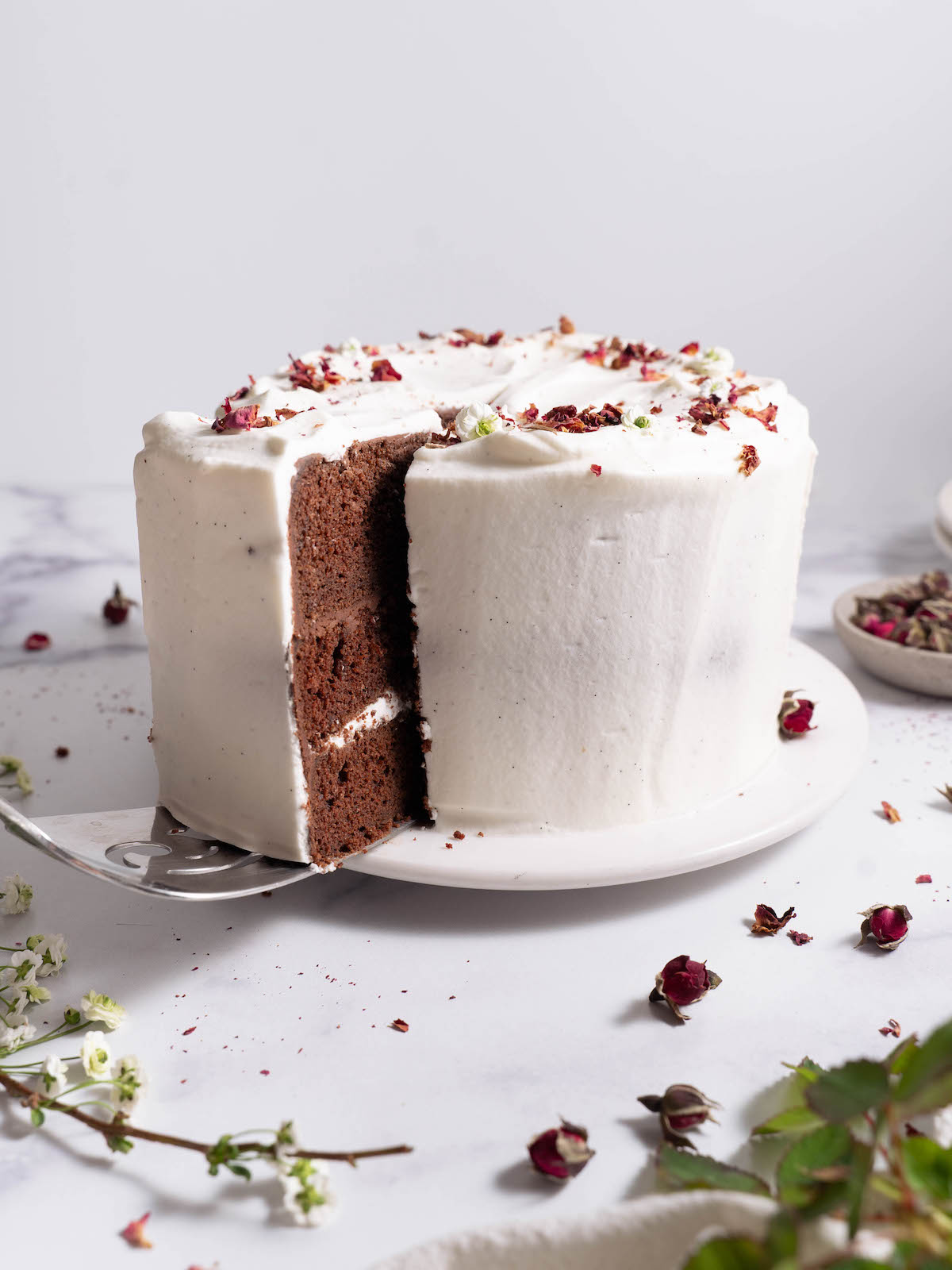 A slice being taken out of a chocolate rose cake
