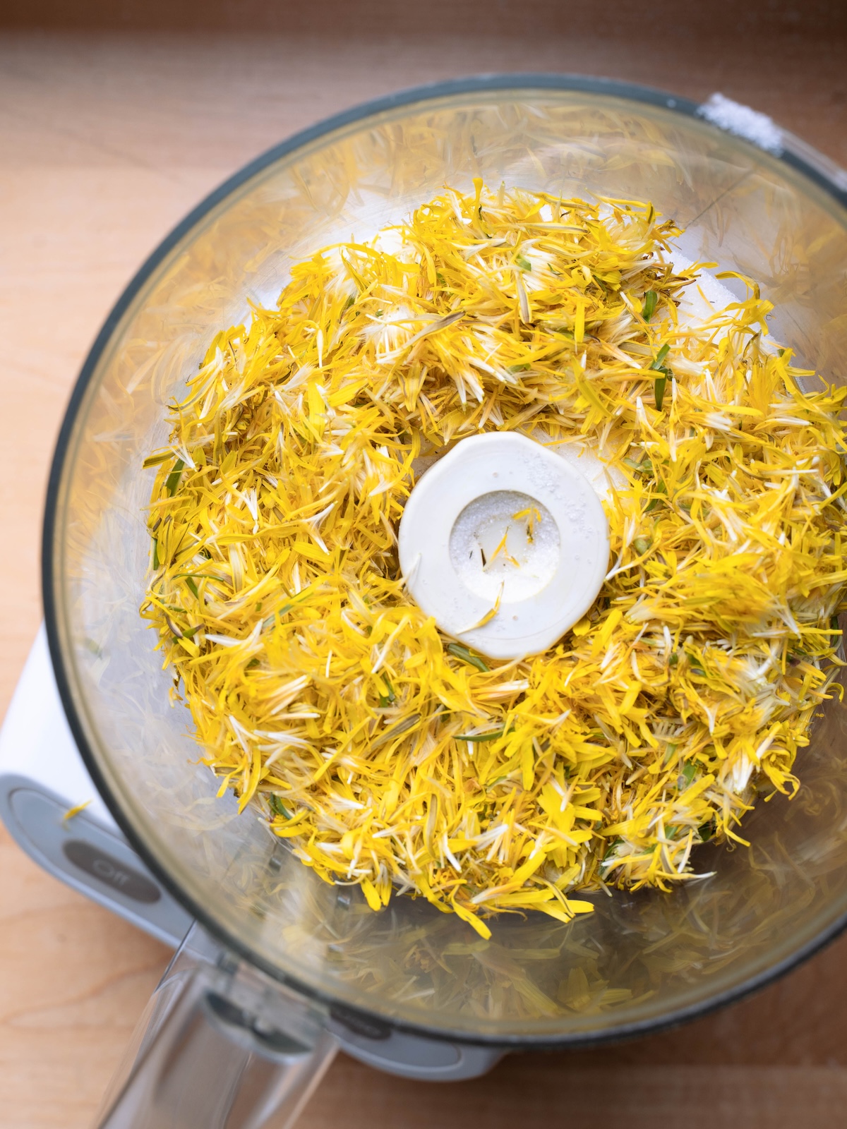 Dandelion petals and sugar in a food processor