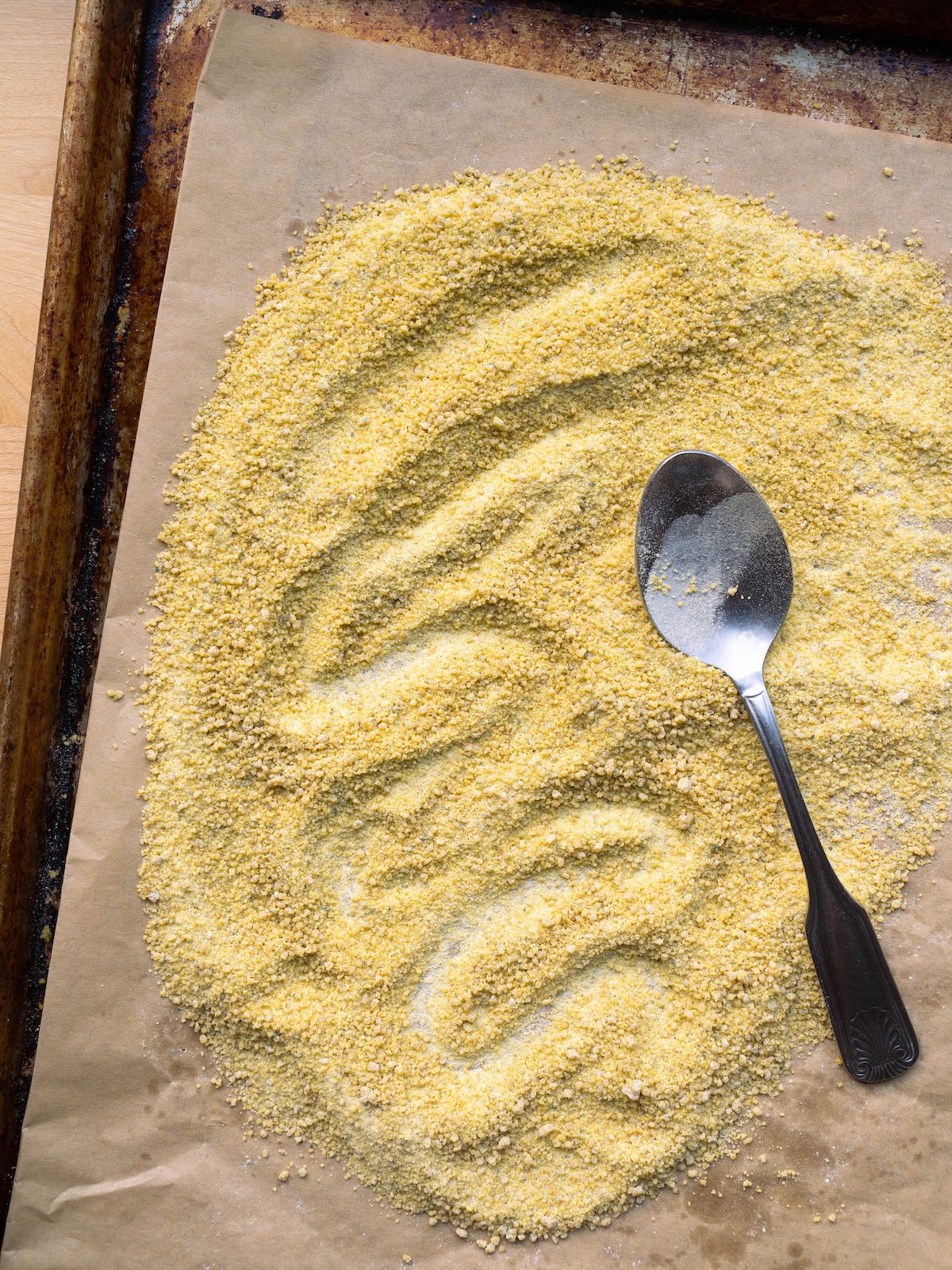 Dandelion sugar on a baking sheet, smoothed out with a spoon