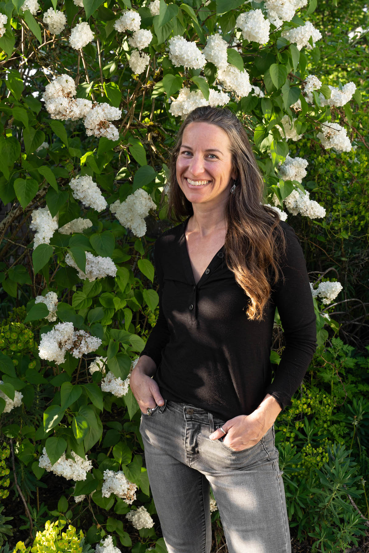 Karie standing in front of a white lilac bush