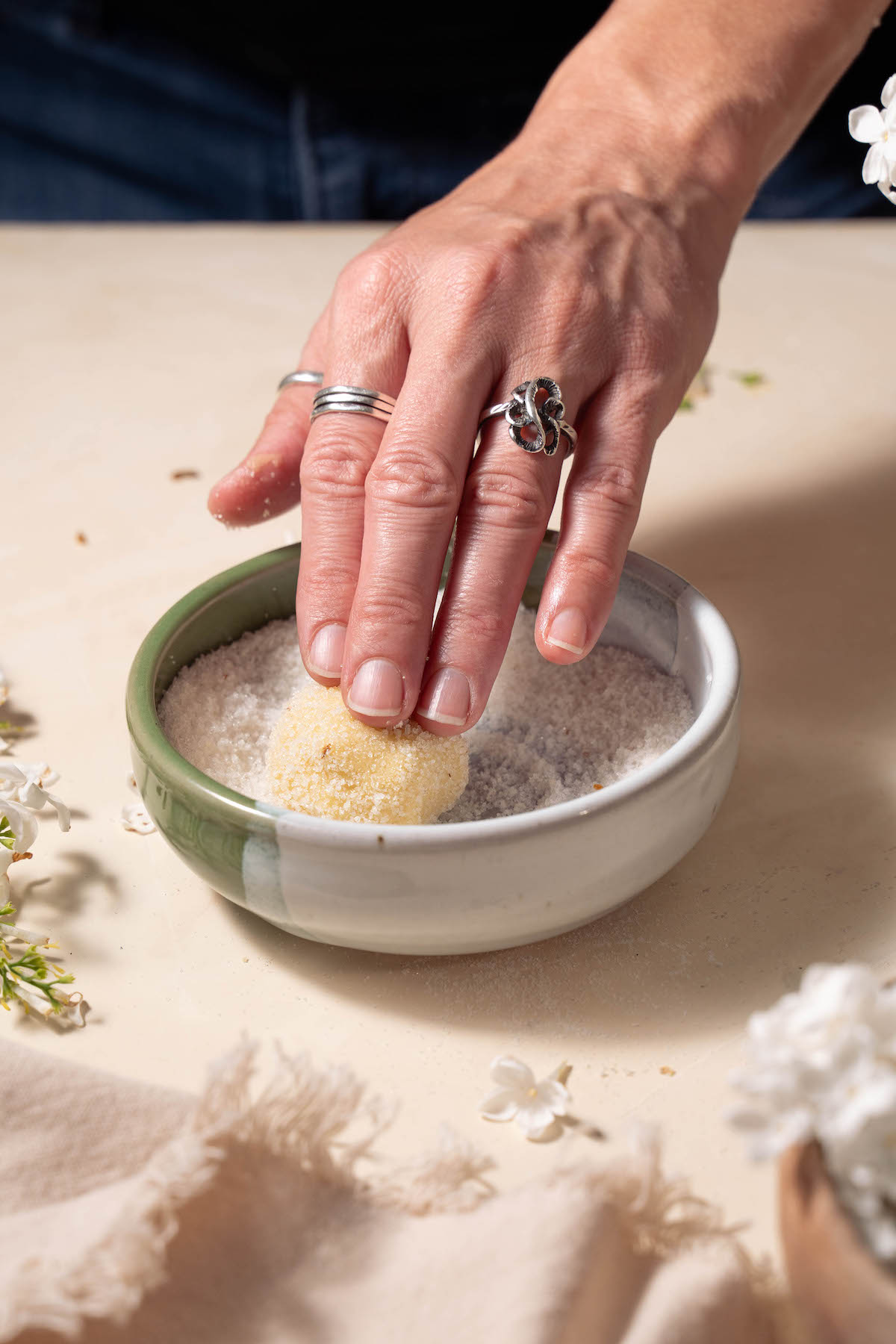 Rolling a cookie dough ball in lilac sugar
