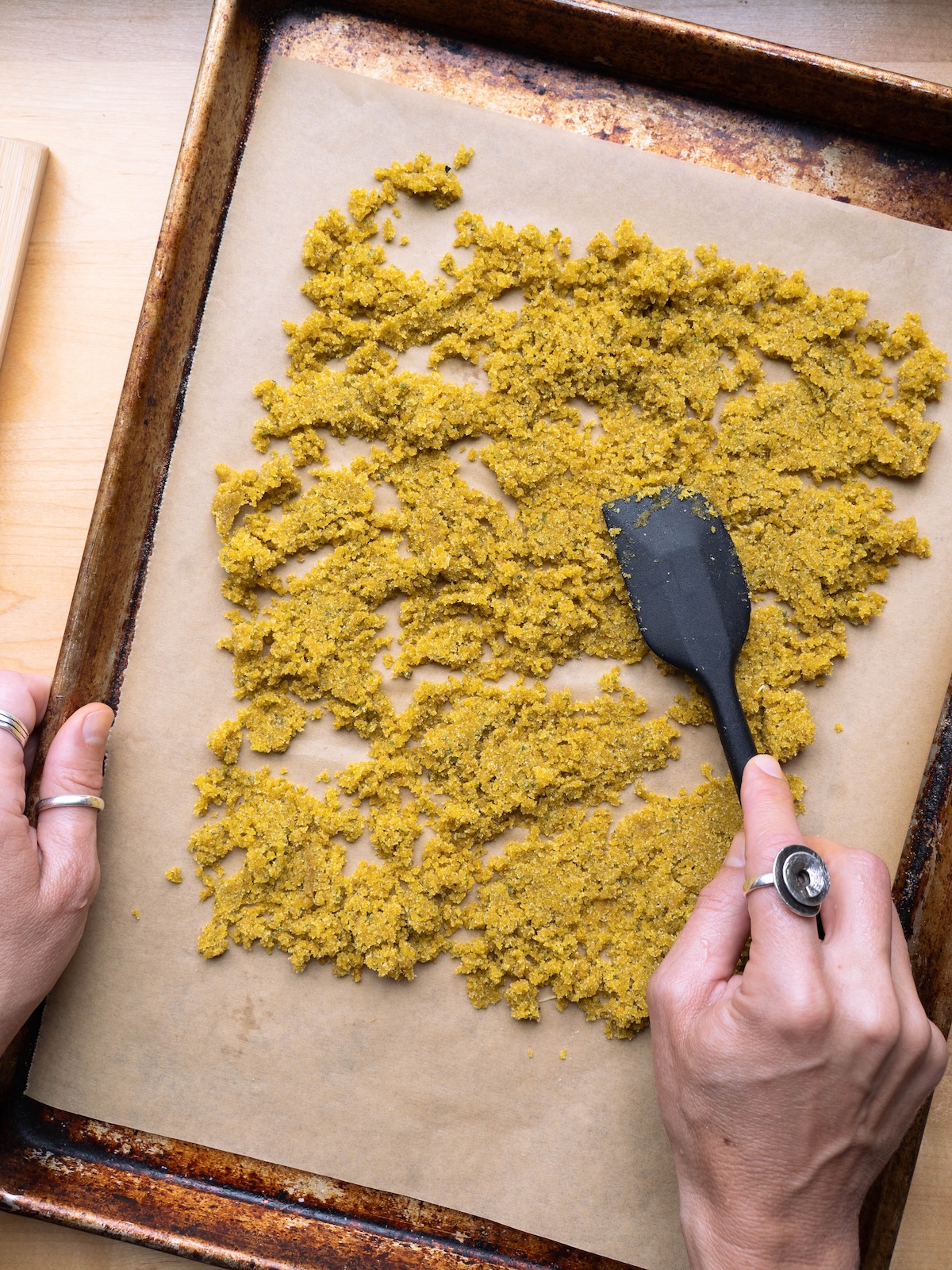 Spreading floral sugar onto a baking sheet to dry