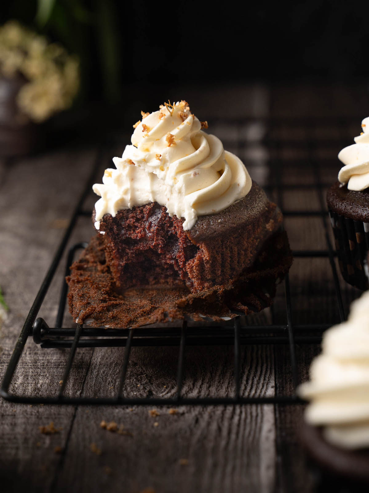A bite taken out of a chocolate elderflower cupcake