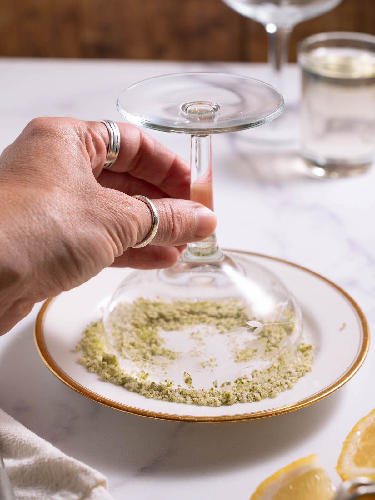 Lining the rim of a coupe glass with fir tip sugar