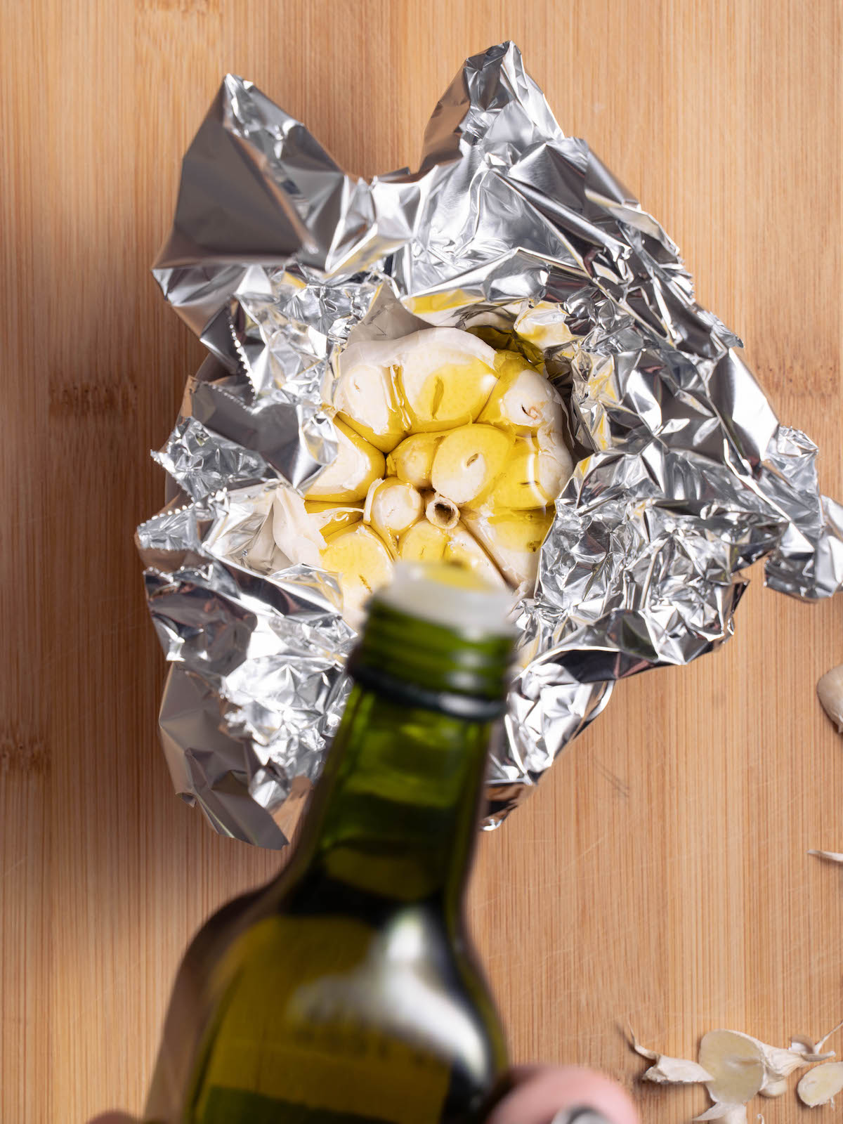 Drizzling olive oil over a head of garlic