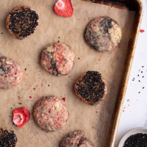 Strawberry black sesame cookies on a baking sheet