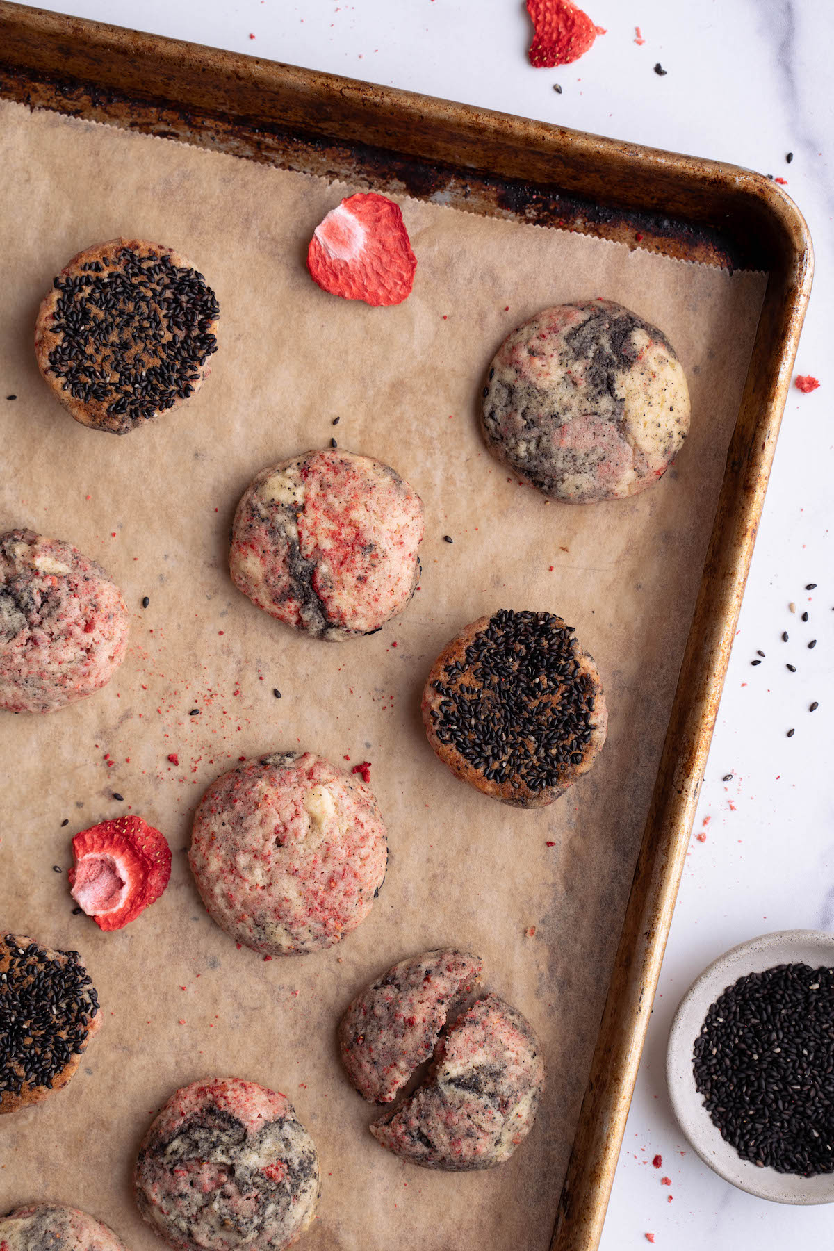 Strawberry black sesame cookies on a baking sheet