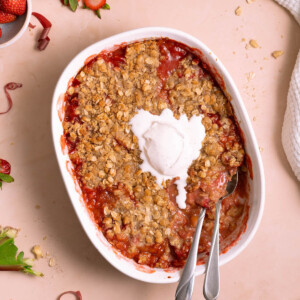 Strawberry rhubarb crisp with whipped cream melting on top