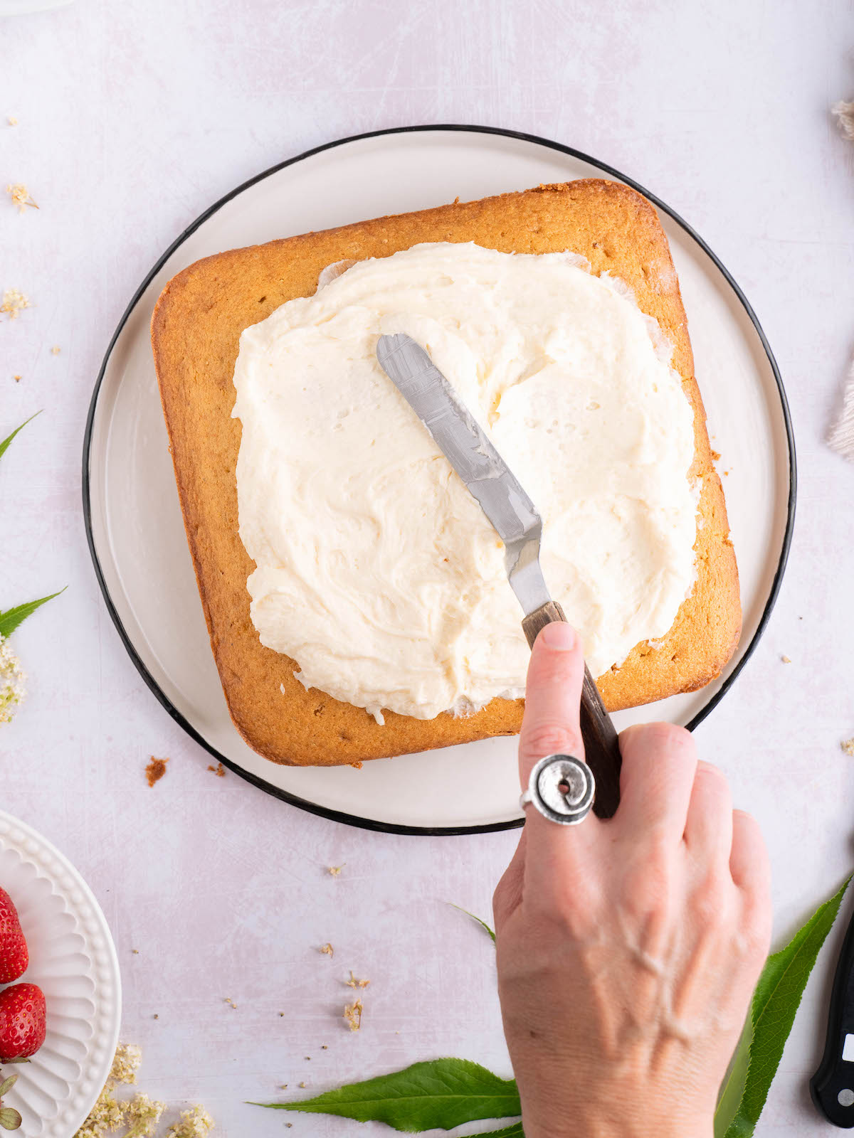 Frosting a cake with elderflower buttercream