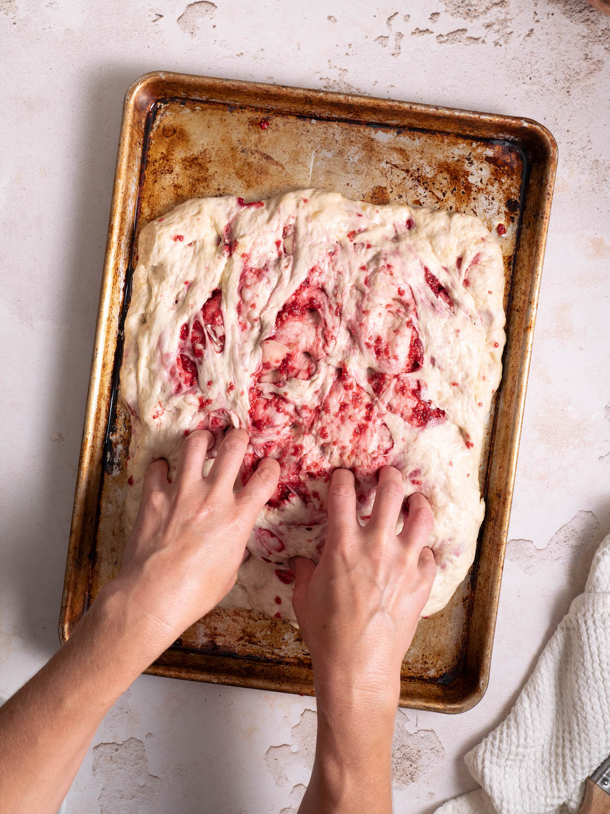 Dimpling focaccia dough before baking