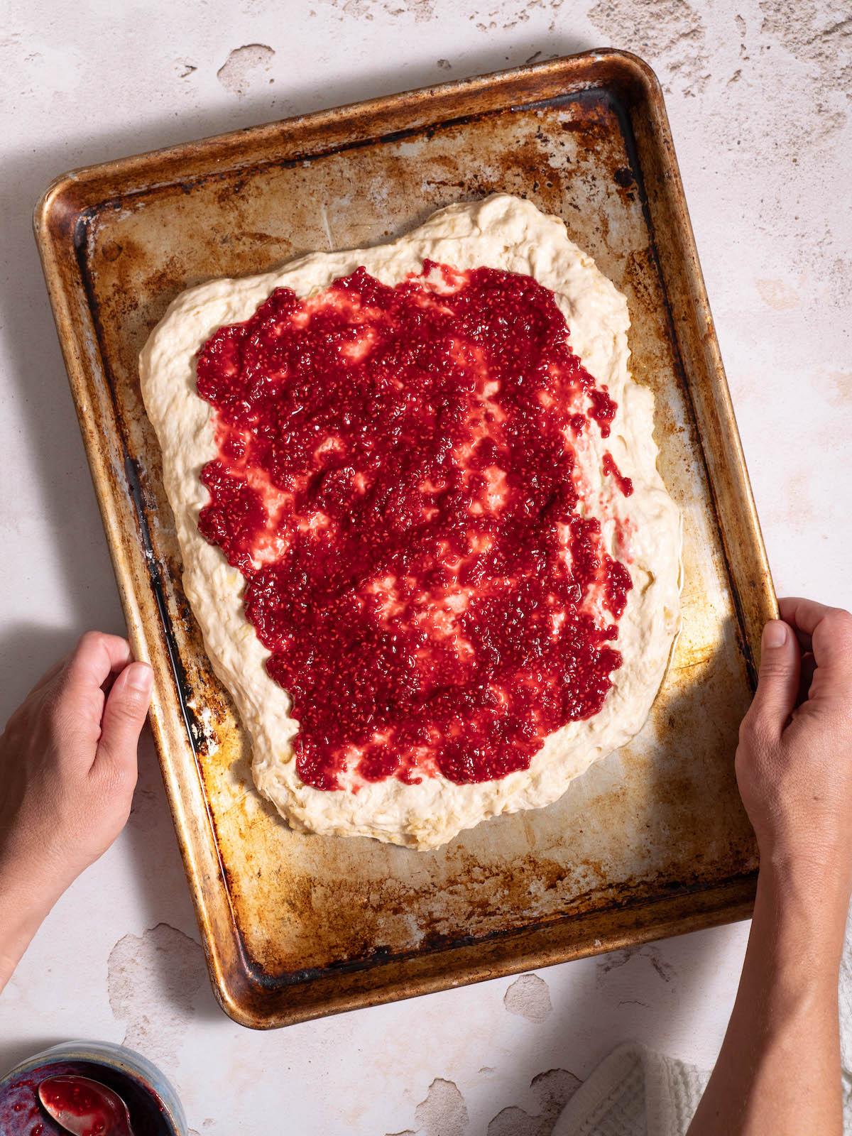 Raspberry jam spread on focaccia dough