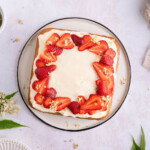 A square elderflower cake topped with strawberries