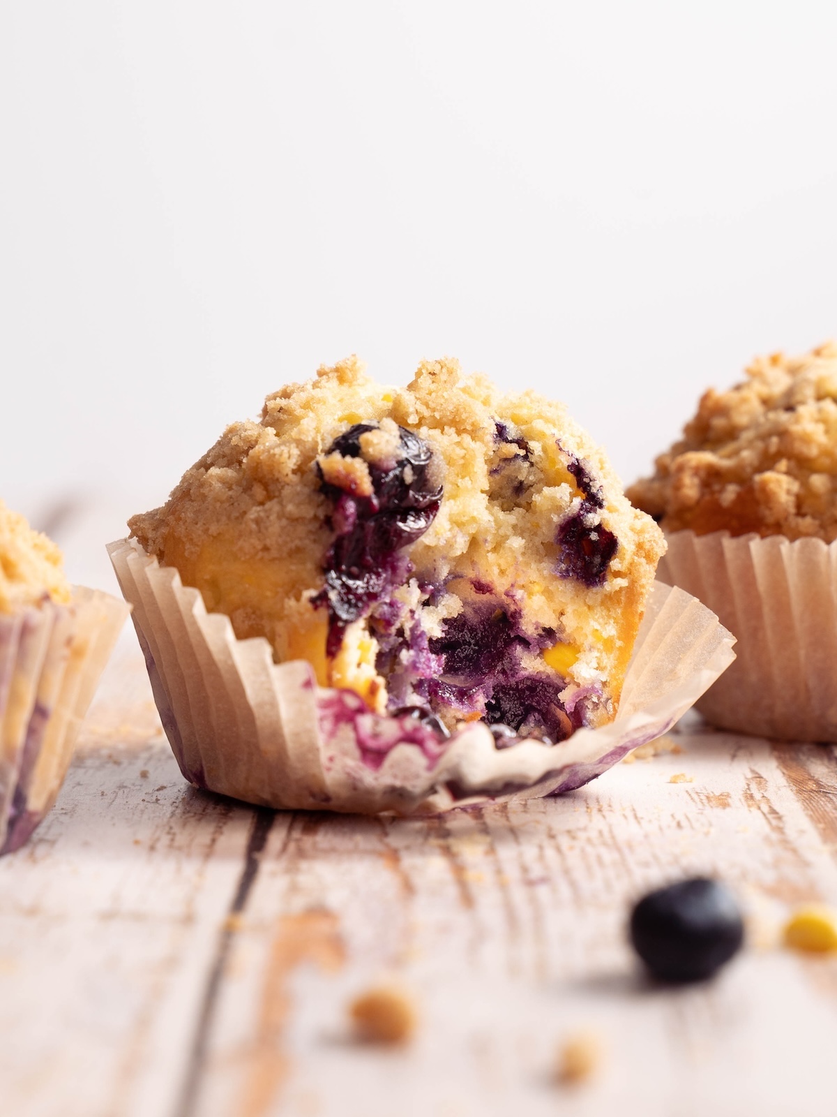 A blueberry sweet corn muffin with a bite taken out of it
