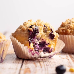 A blueberry corn muffin with a bite taken out of it