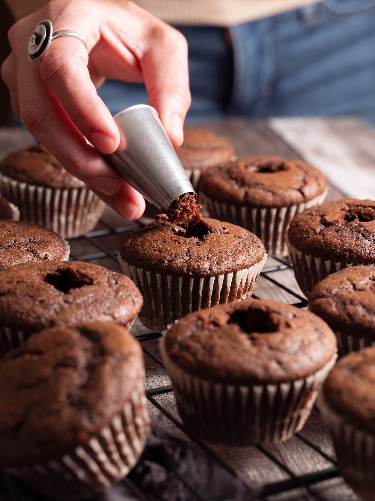 Cutting a hole in the center of a chocolate cupcake