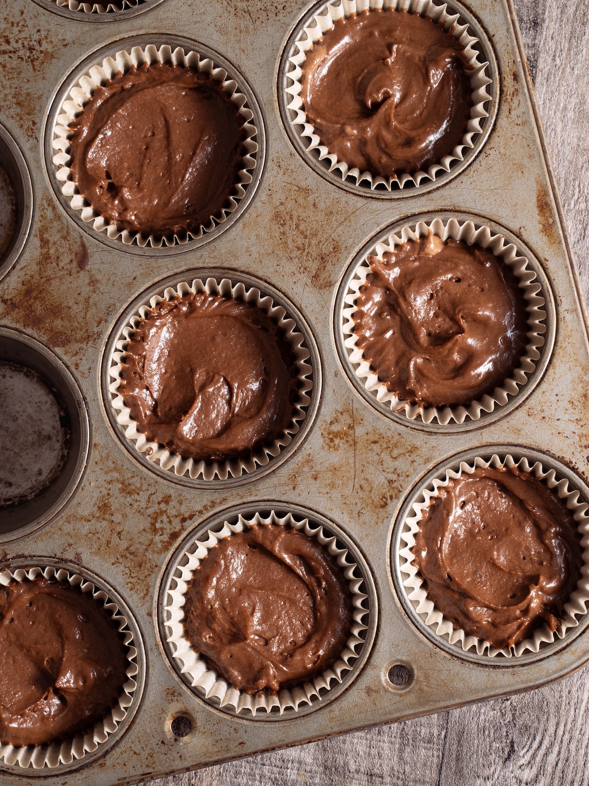 Chocolate cupcakes in a cupcake pan before baking