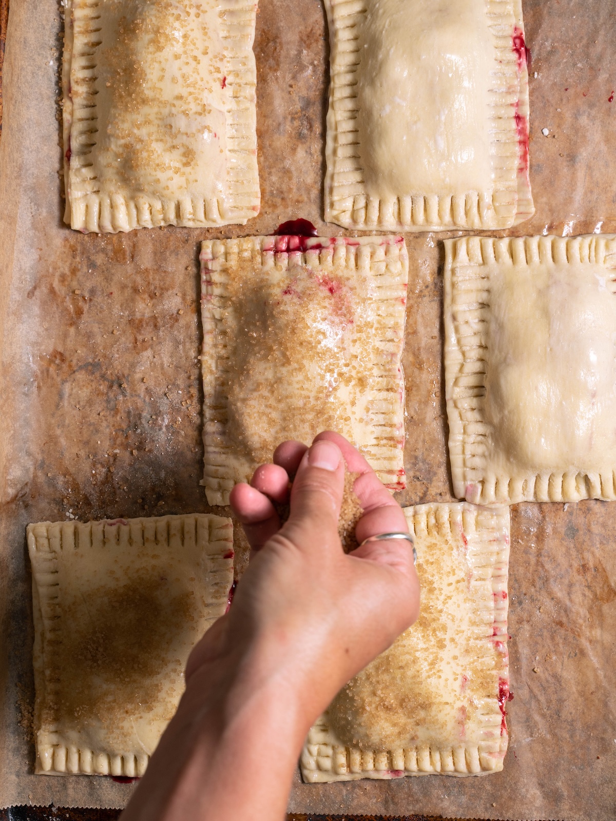 Sprinkling coarse sugar on top of hand pies