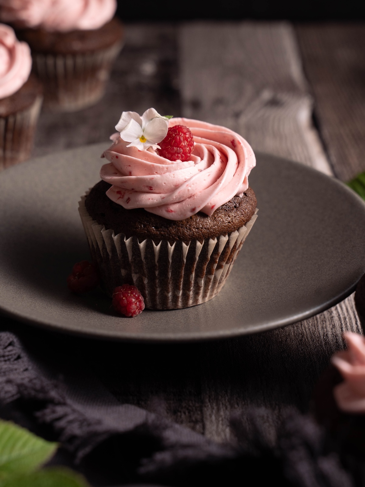 A chocolate cupcake with fresh raspberry buttercream
