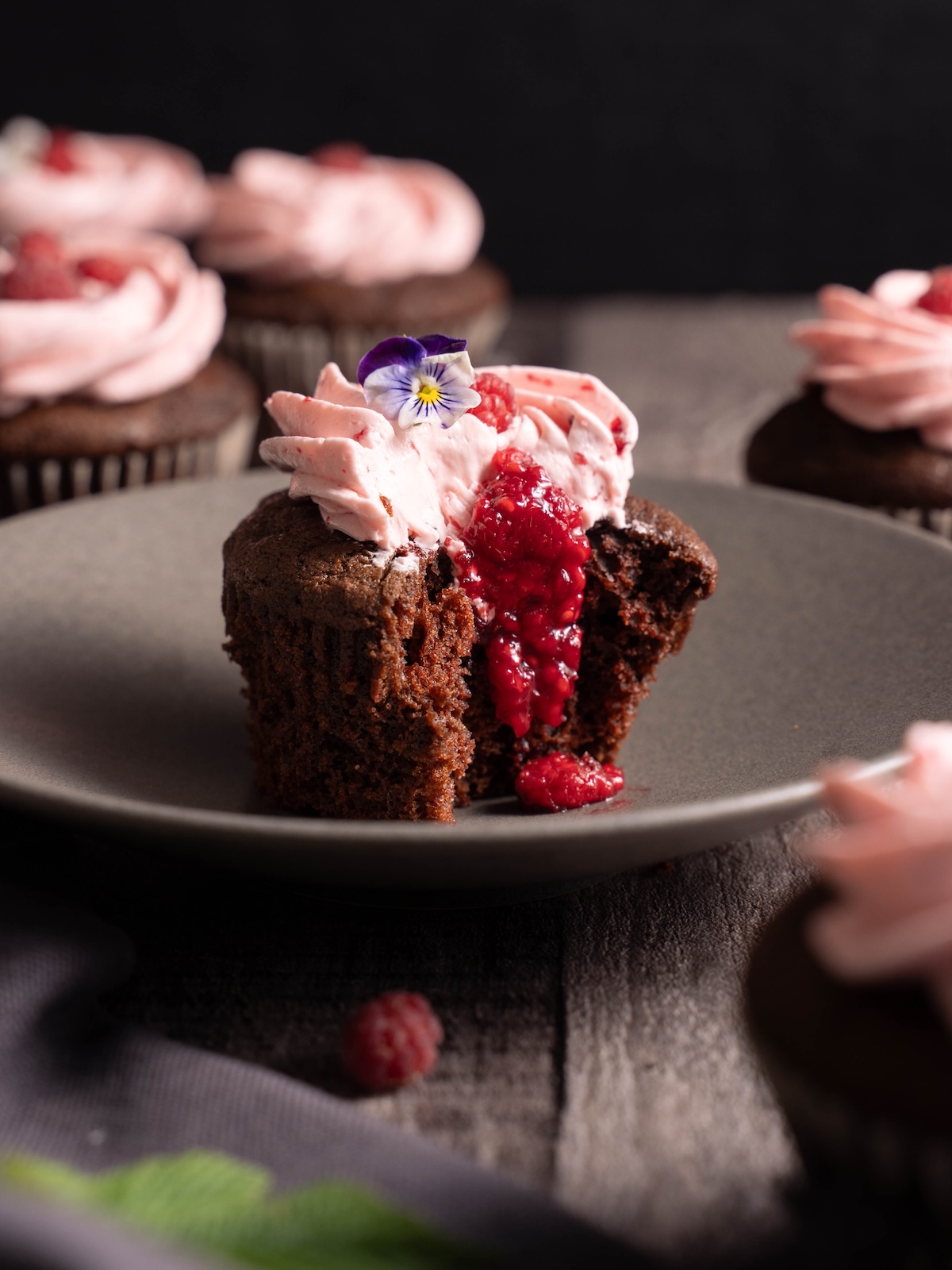 A chocolate and raspberry cupcake on a plate