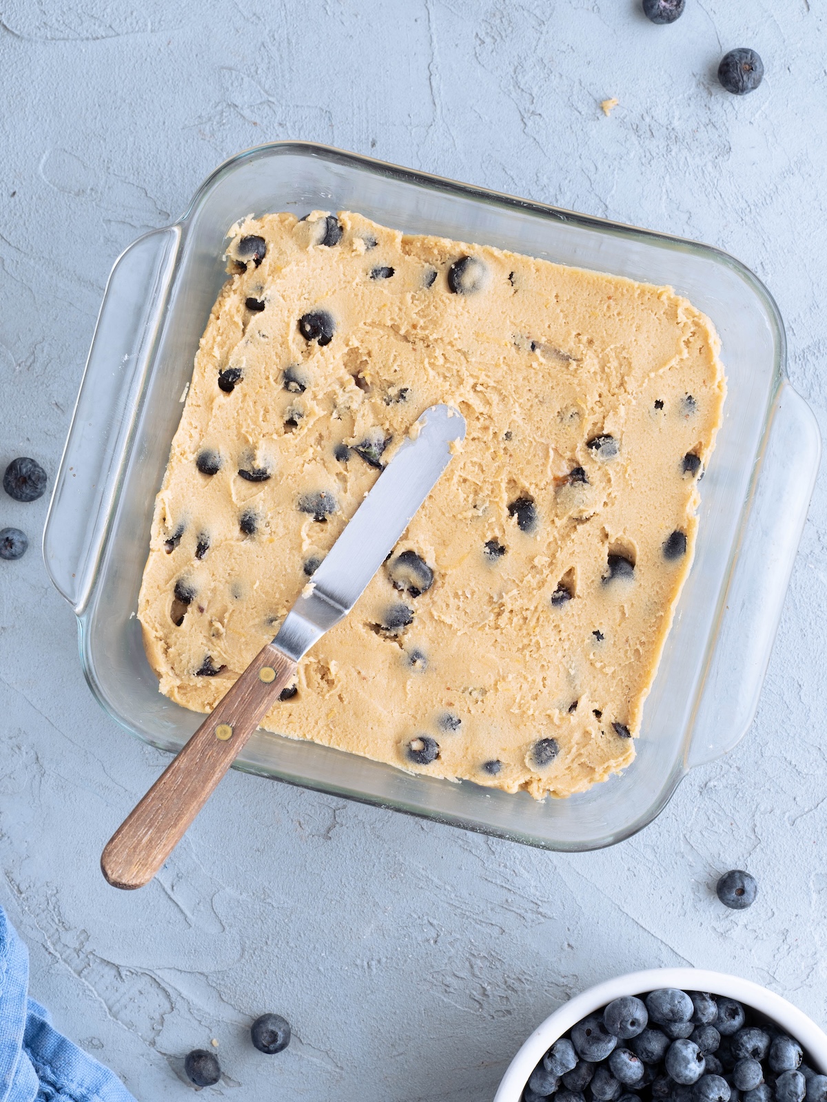 Blueberry blondie batter spread in a pan, ready to bake