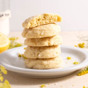 A stack of lemon and fennel pollen sugar cookies, surrounded by fennel flowers