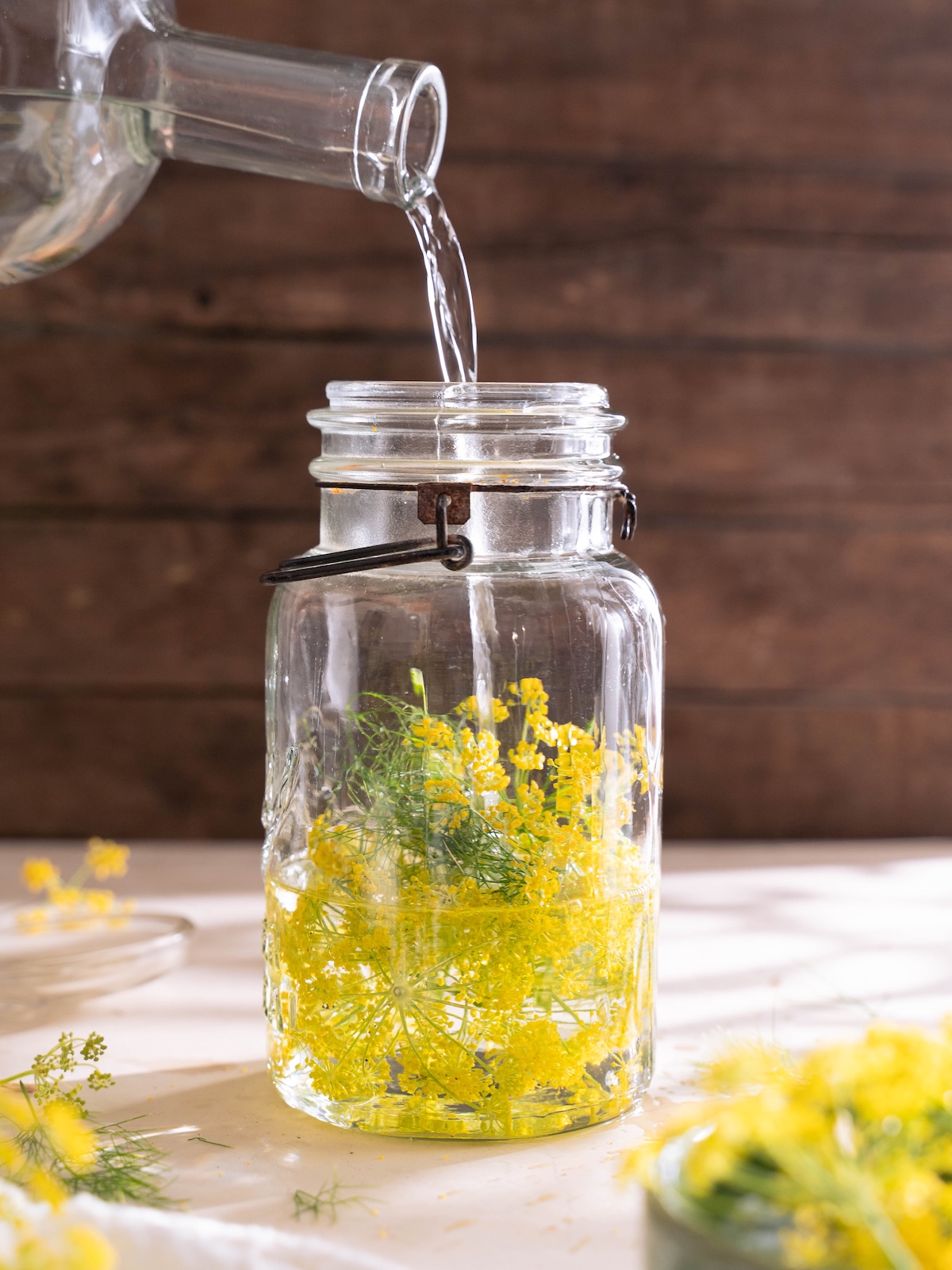 Pouring vodka over fresh fennel flowers