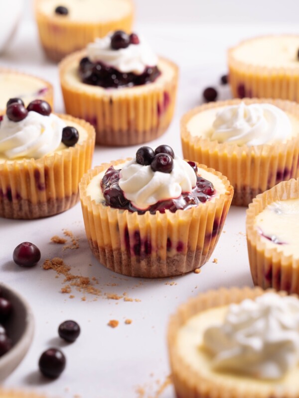 Mini huckleberry cheesecakes topped with huckleberry compote and whipped cream