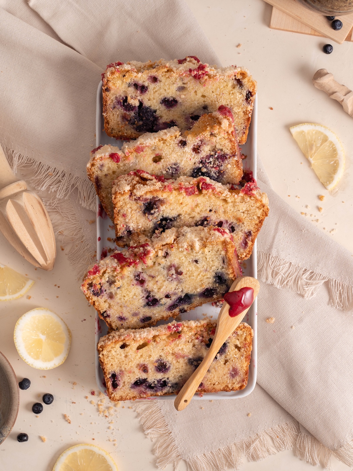 A serving platter filled with slices of lemon huckleberry loaf cake