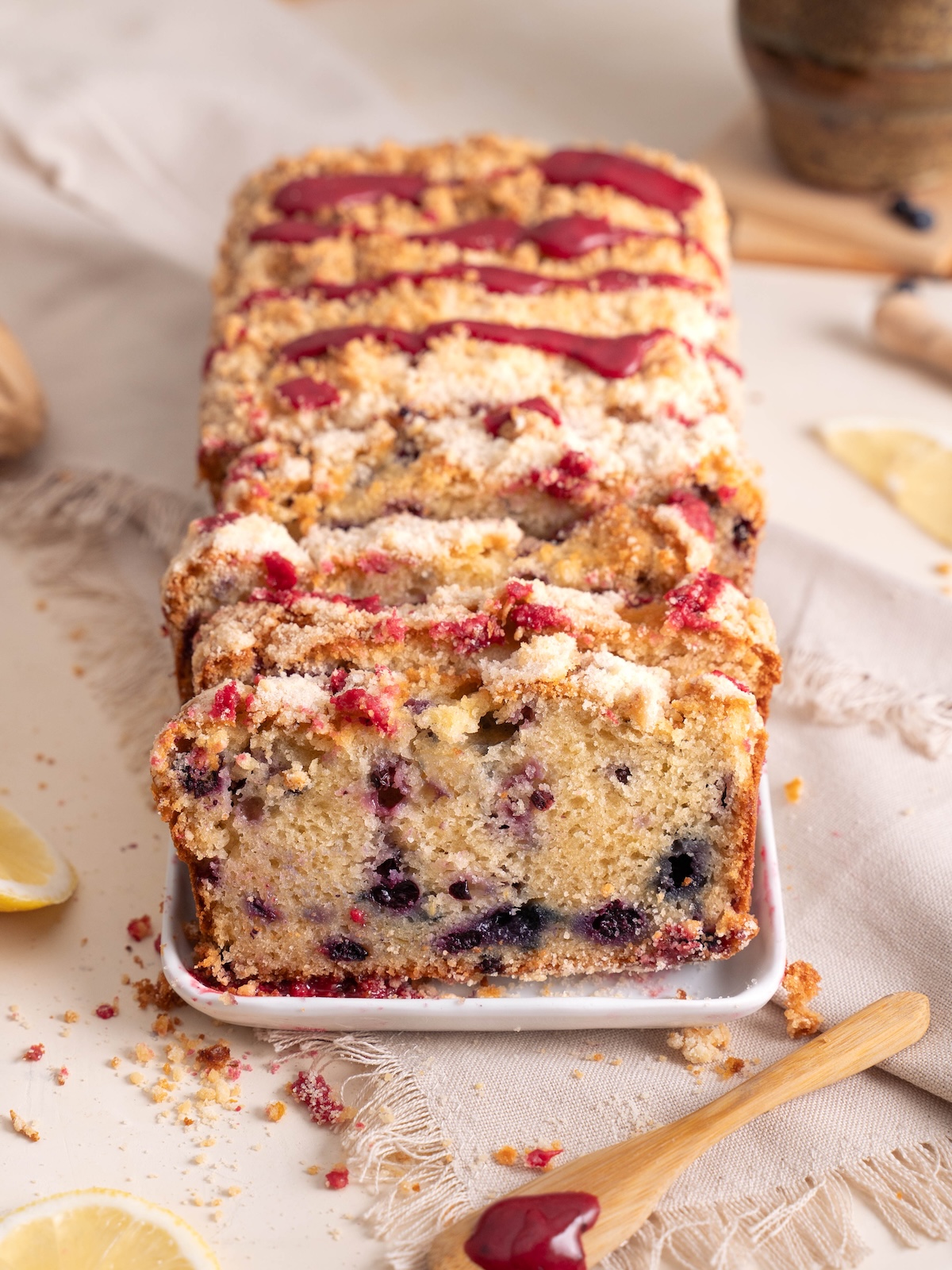 A loaf cake, sliced and drizzled with fresh huckleberry glaze