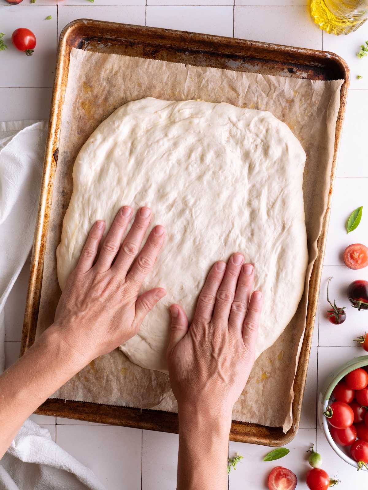 Hands gently pressing and stretching bread dough