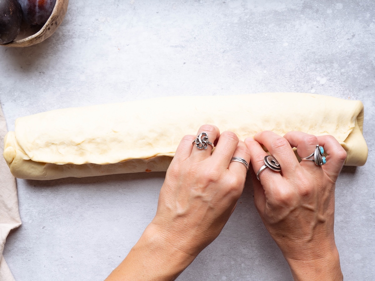 Pinching a cinnamon roll to seal it shut