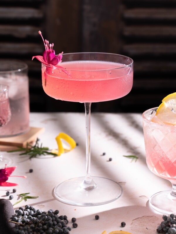 An elderberry rosemary sour in a large cocktail glass