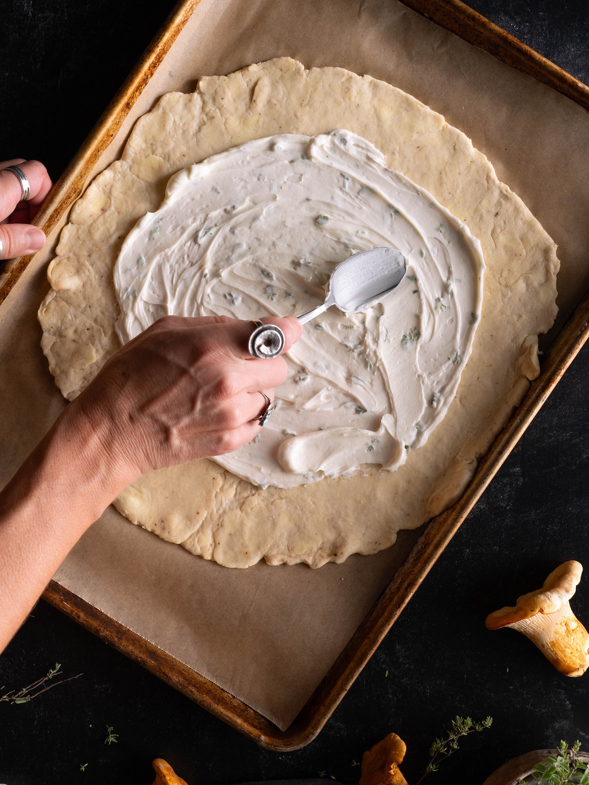 Spreading soft goat cheese onto parmesan pie crust